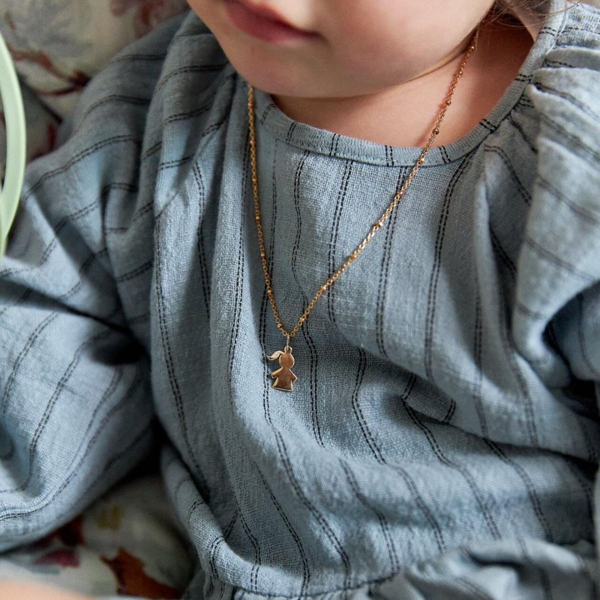 Enfant portant un collier 1 mini breloque sur chaîne perlée plaqué or